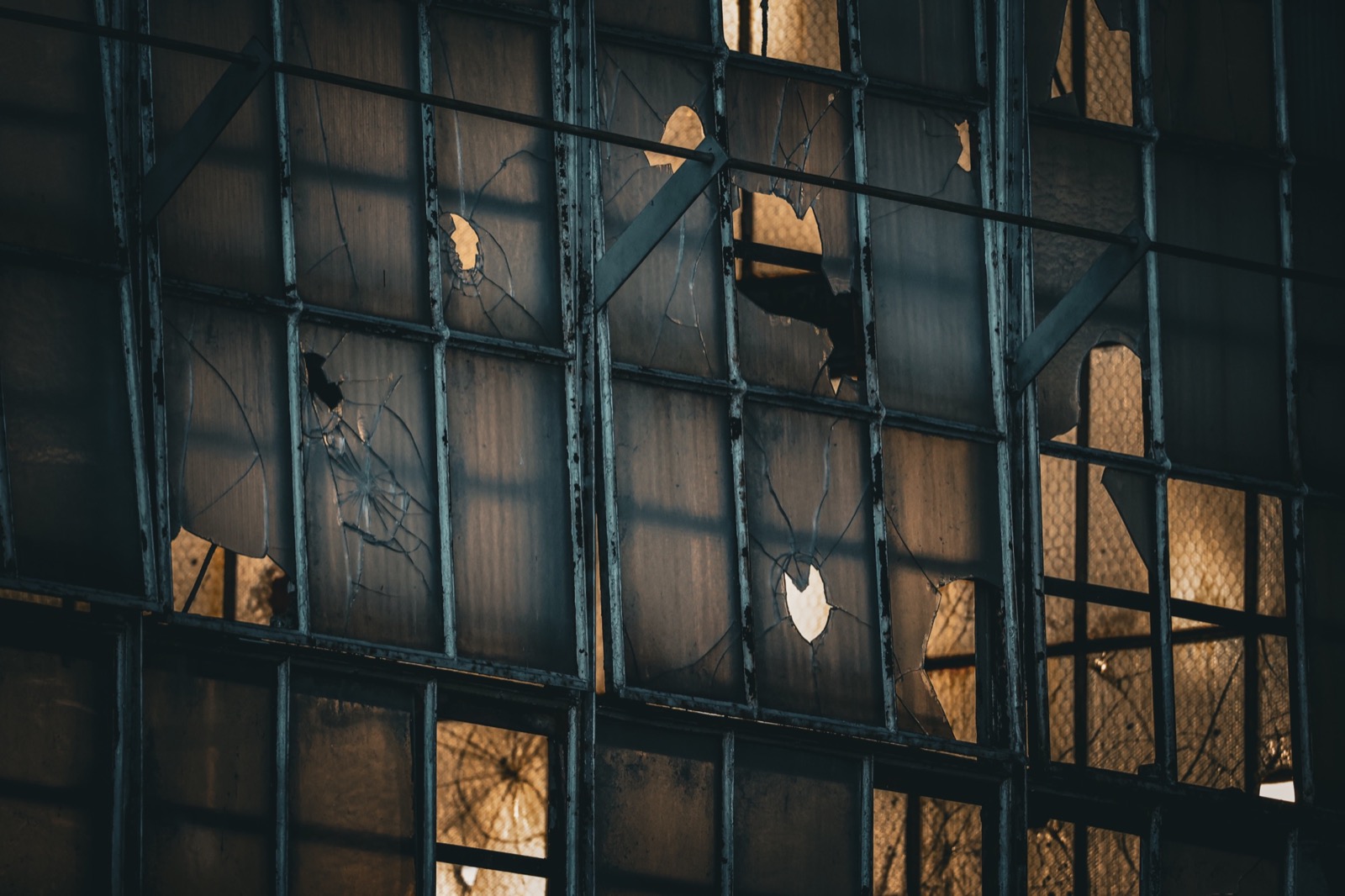 Warm light through the broken windows of an industrial building.